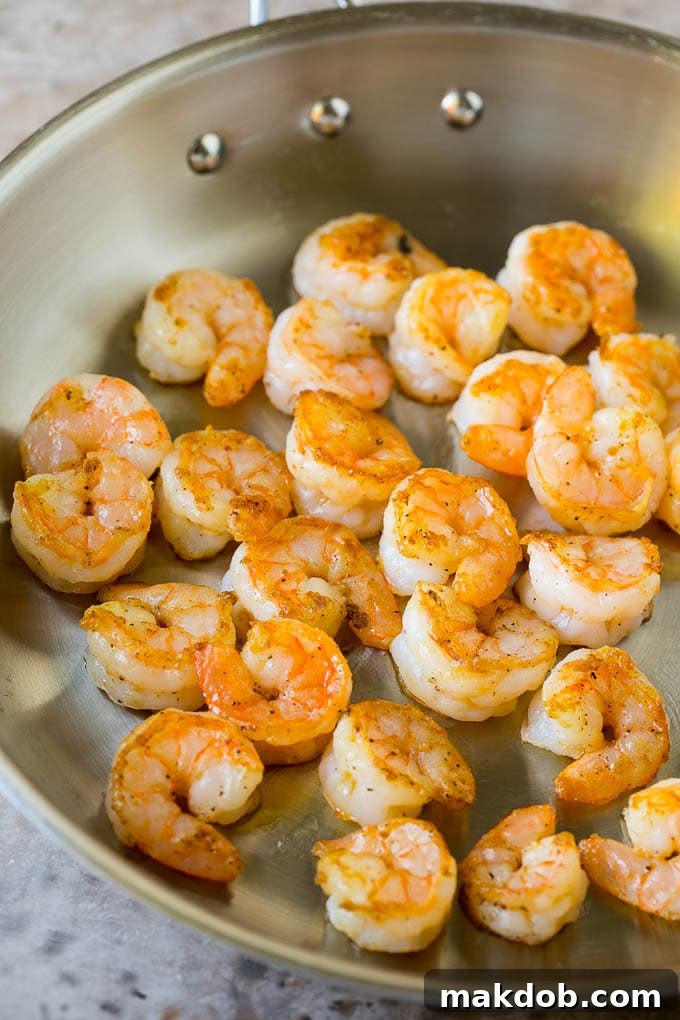 Shrimp Fried Rice Recipe | Chinese Fried Rice #rice #shrimp #peas #carrots #sidedish #dinner #dinneratthezoo Perfectly cooked shrimp, pink and opaque, resting in a skillet, ready to be set aside for the fried rice.