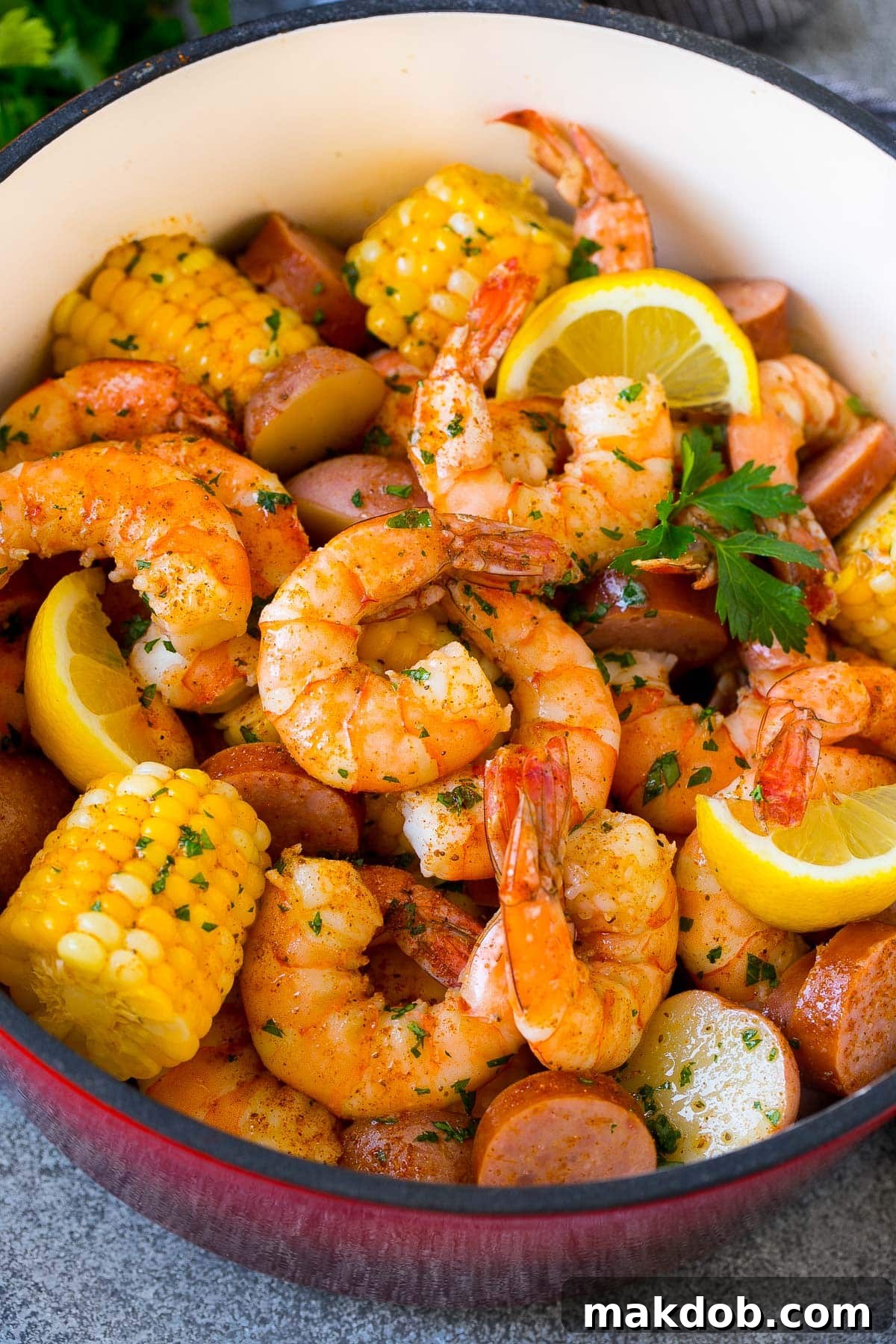 Ultimate Backyard Shrimp Boil 6 A shrimp boil with potatoes and corn in a vibrant red pot, ready for serving.