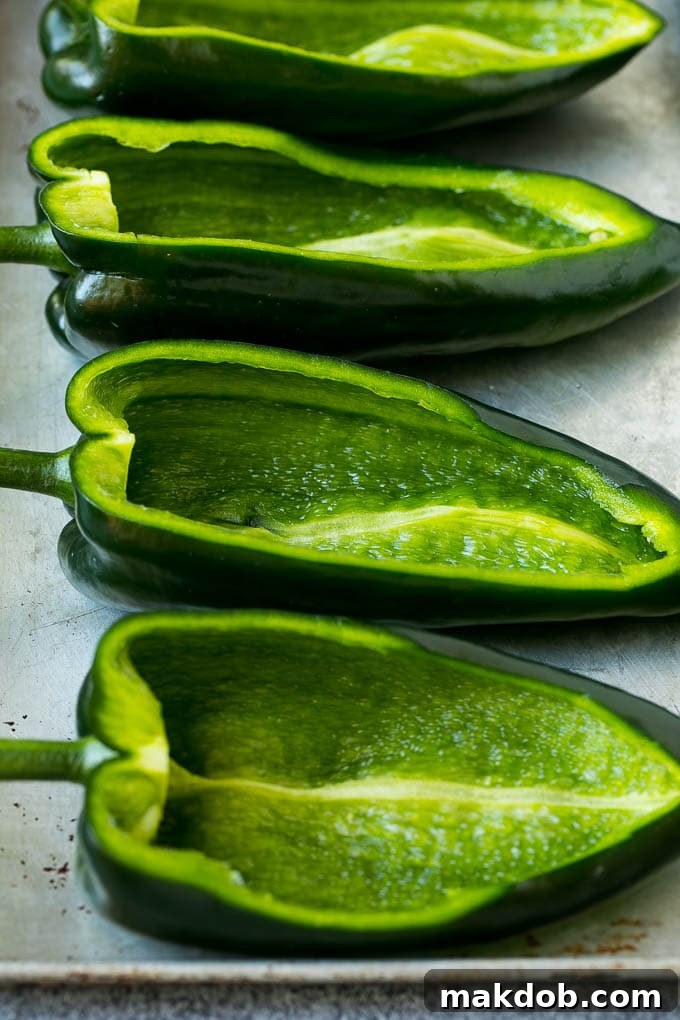 Hollowed out poblano peppers on a pan.