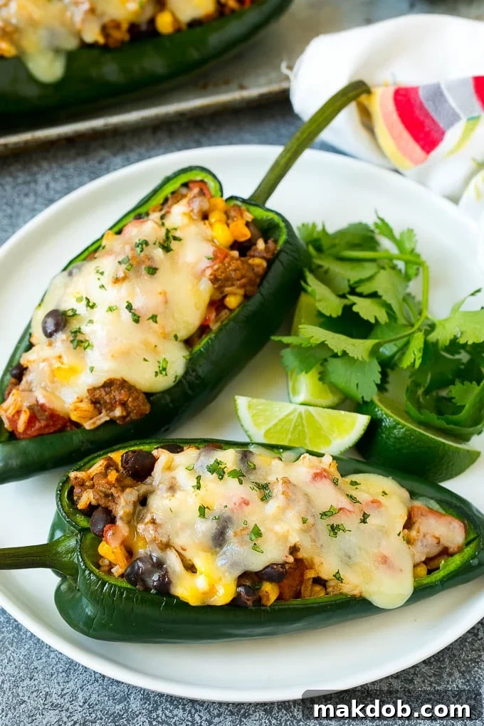 A plate of stuffed poblano peppers topped with melted cheese.