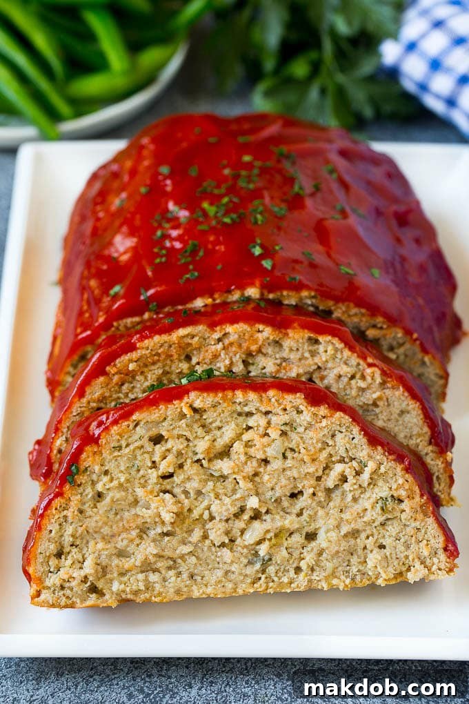 Turkey Meatloaf Recipe | Healthy Meatloaf #meatloaf #turkey #dinner #dinneratthezoo A sliced turkey meatloaf topped with ketchup and chopped parsley.