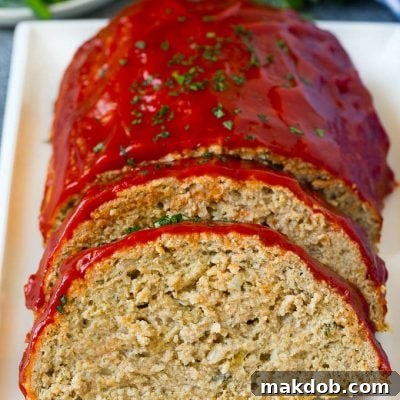 Simple Weeknight Turkey Meatloaf 5 A sliced turkey meatloaf topped with ketchup and chopped parsley.