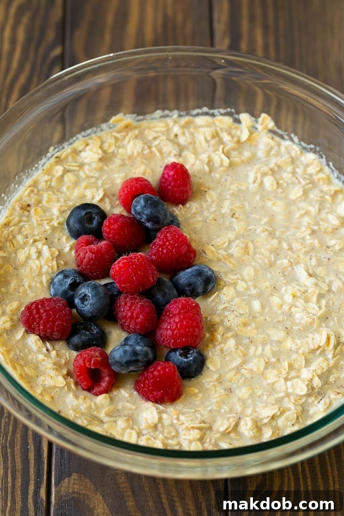 Baked Oatmeal Recipe | Meal Prep | Healthy Oatmeal #oatmeal #casserole #breakfast #brunch #dinneratthezoo #mealprep A bowl of oatmeal mixed with milk with fresh berries on top.
