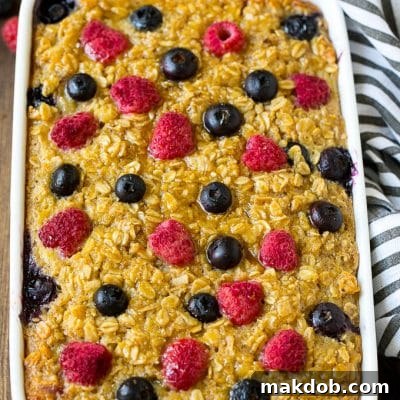 A dish of baked oatmeal with blueberries and raspberries on top.