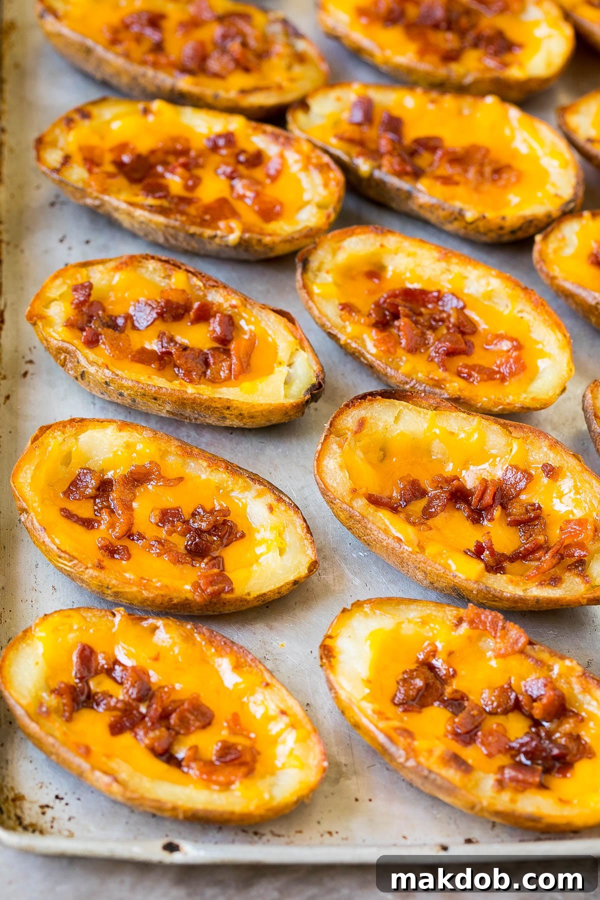 Ultimate Cheesy Bacon Potato Skins 3 Crispy potato halves generously topped with melted cheese and savory bacon, waiting for their final garnishes.