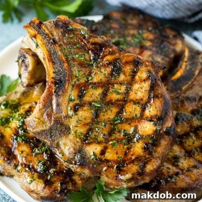 Chargrilled Pork Perfection 2 Grilled pork chops coated in marinade then cooked and garnished with parsley.