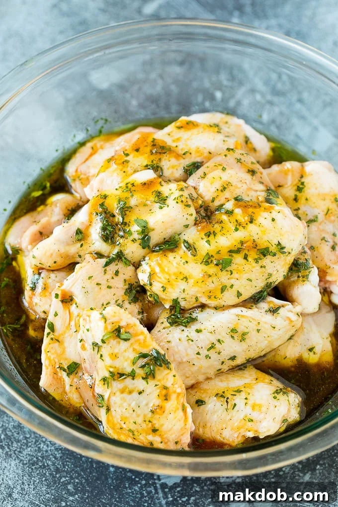 Chicken wings soaking in a bowl of flavorful marinade.