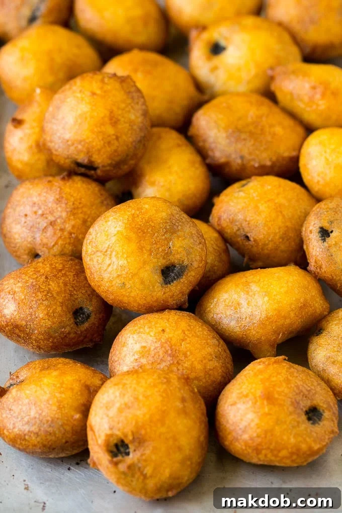 Freshly deep-fried Oreo cookies cooling on a sheet pan.