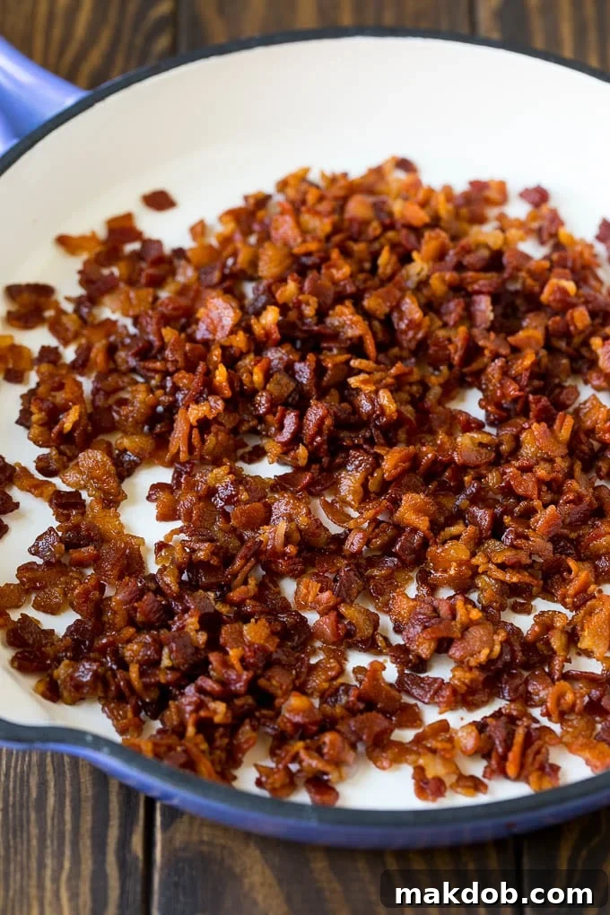 Crispy cooked bacon pieces in a cast iron skillet.