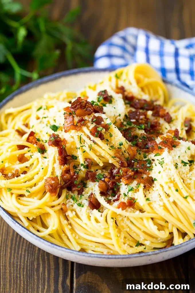 A beautifully plated bowl of carbonara pasta, garnished with bacon and cheese, ready to serve.