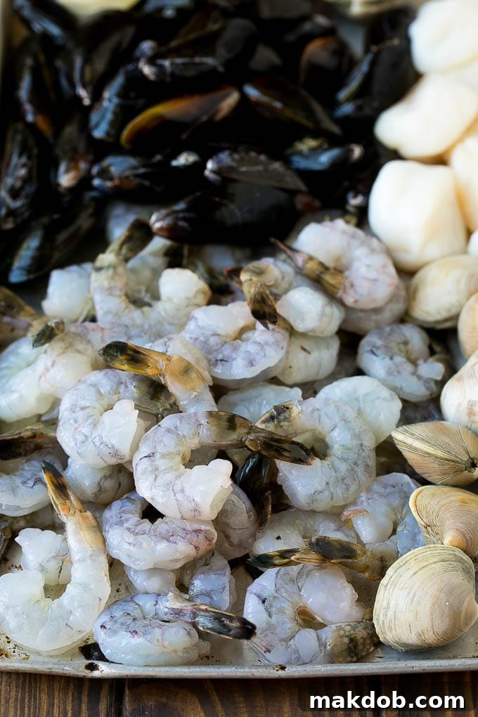 Raw shrimp, mussels, clams and scallops on a sheet pan.