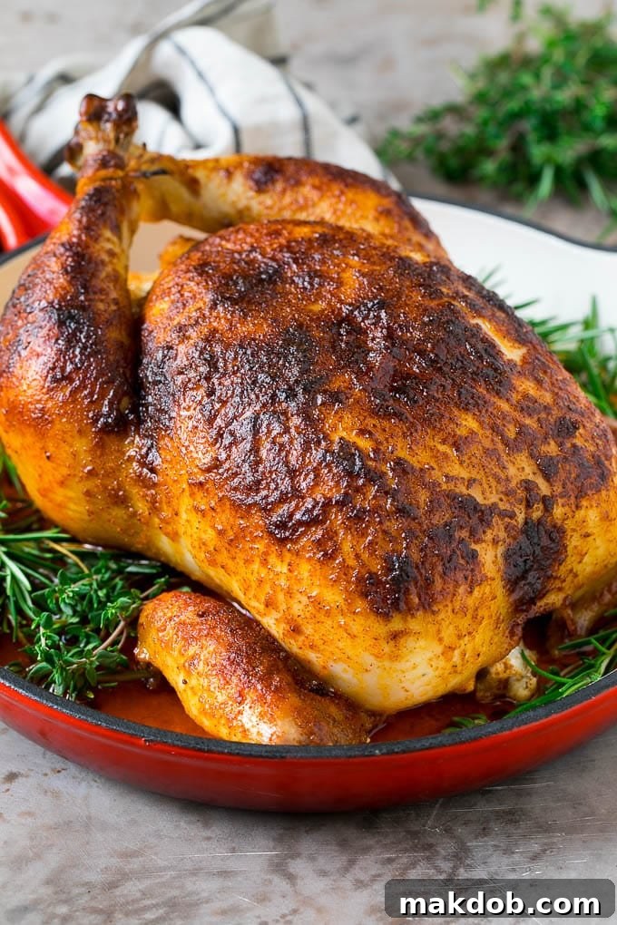 Rotisserie chicken in a skillet garnished with fresh herbs.