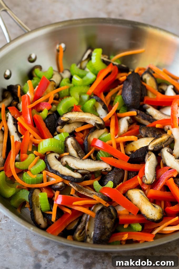 Mushrooms, bell pepper, celery and carrot in a pan.