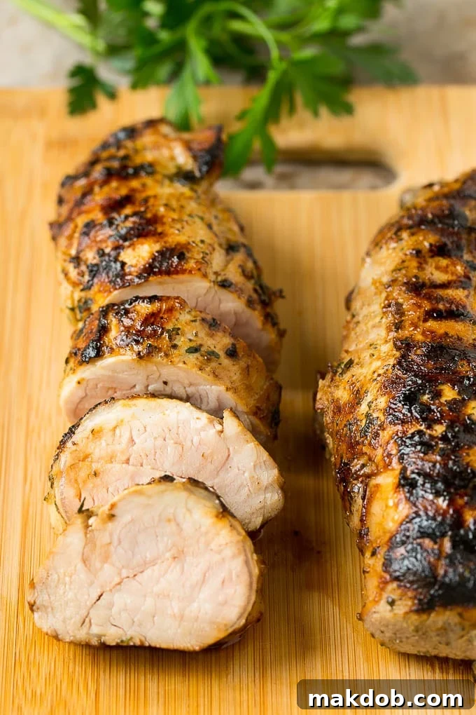 Sliced pork tenderloin on a cutting board.