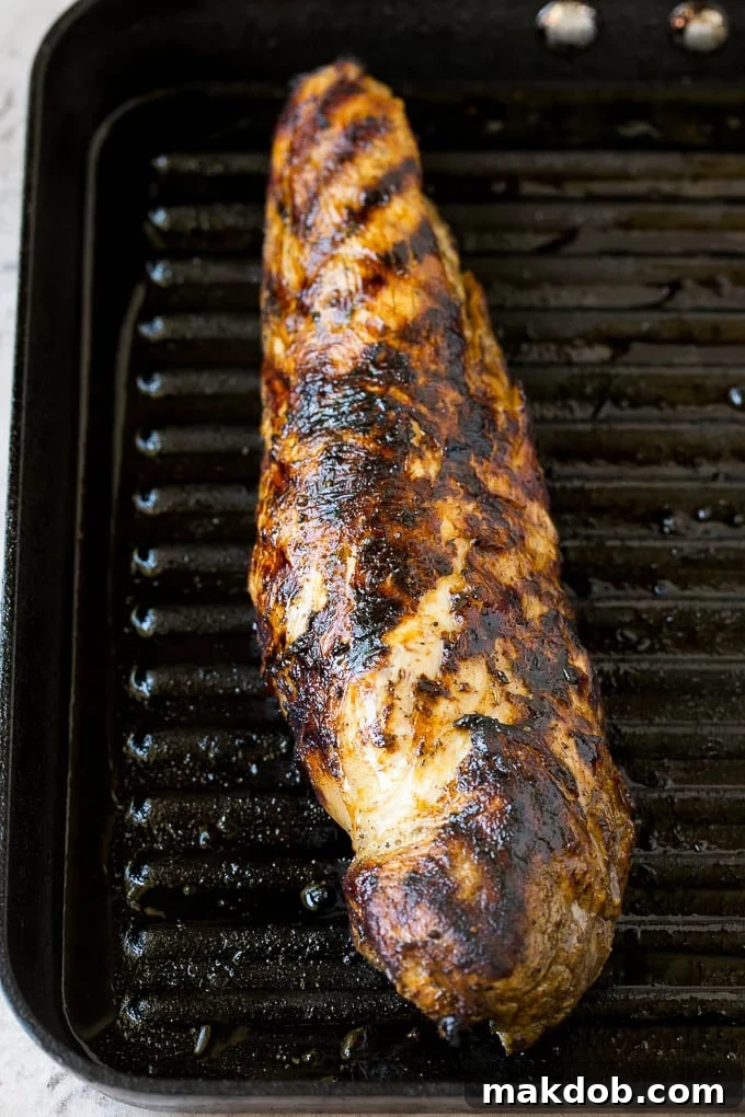 Grilled Pork Tenderloin for Cuban Sandwich Grilled pork tenderloin, thinly sliced, resting on a cutting board, ready to be assembled into Cuban sandwiches.