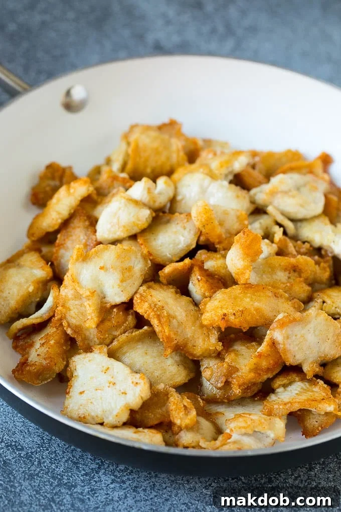 Thinly sliced chicken browned in a pan.