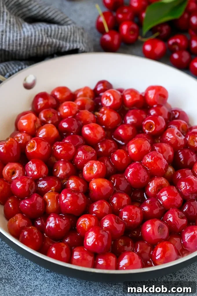 Cherry Pie Filling Recipe #pie #cherries #dessert #sweets #dinneratthezoo #summer Cooked cherries simmering in a skillet, showcasing the thickening process of the pie filling.