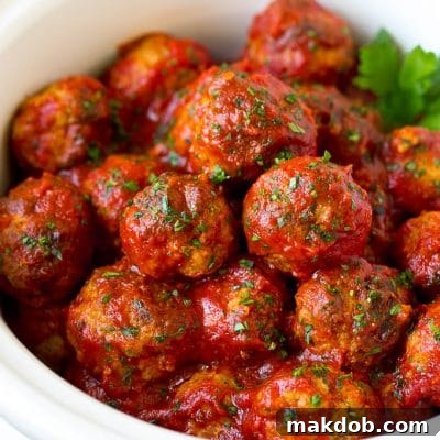 Turkey meatballs in tomato sauce inside a slow cooker.