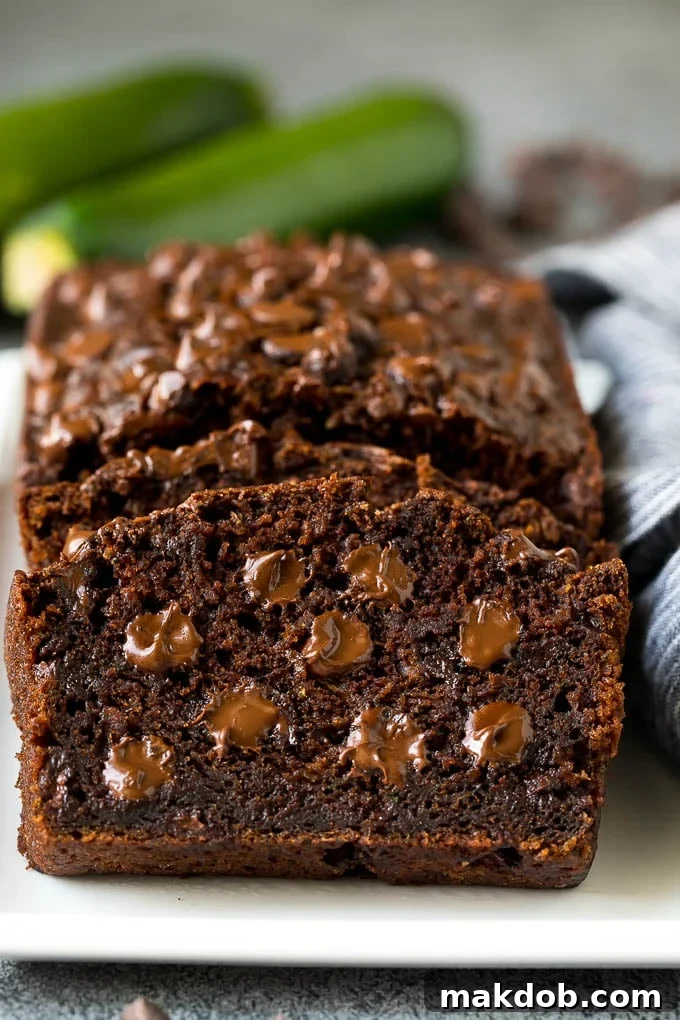 A freshly baked slice of chocolate zucchini bread showing its moist texture and melted chocolate chips.