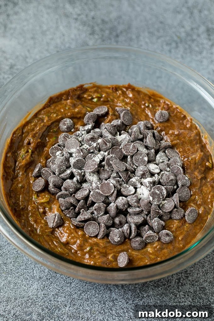 Chocolate zucchini bread batter in a mixing bowl with chocolate chips ready to be folded in.