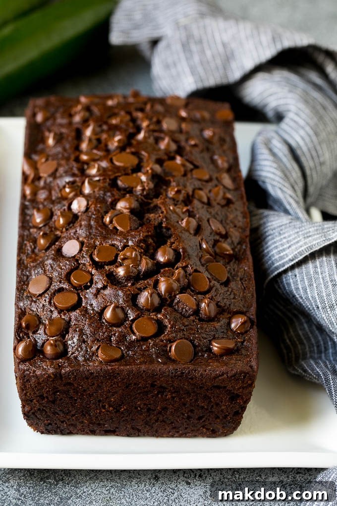 A perfectly baked loaf of chocolate zucchini bread, beautifully adorned with melted chocolate chips on top.
