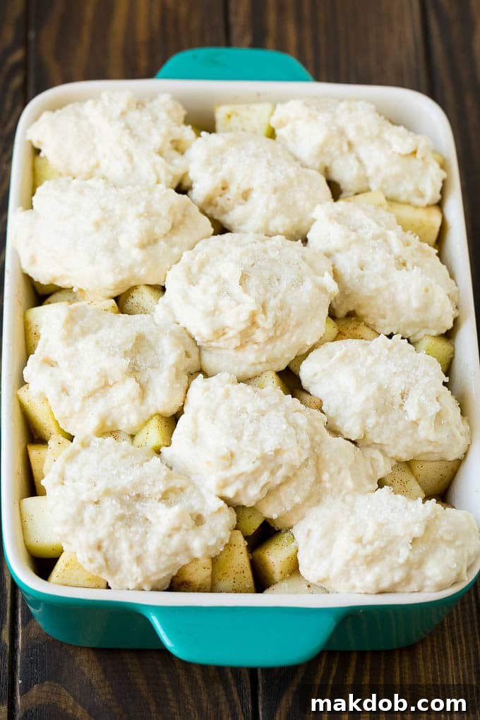 Apple Cobbler Recipe | Apple Dessert #apples #cobbler #dessert #baking #fall #dinneratthezoo Fruit in a baking dish with dough over the top.