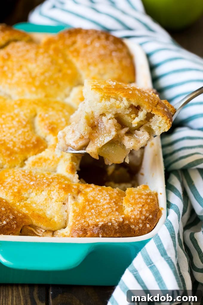 Apple Cobbler Recipe | Apple Dessert #apples #cobbler #dessert #baking #fall #dinneratthezoo A spoonful of apple cobbler in the serving dish.