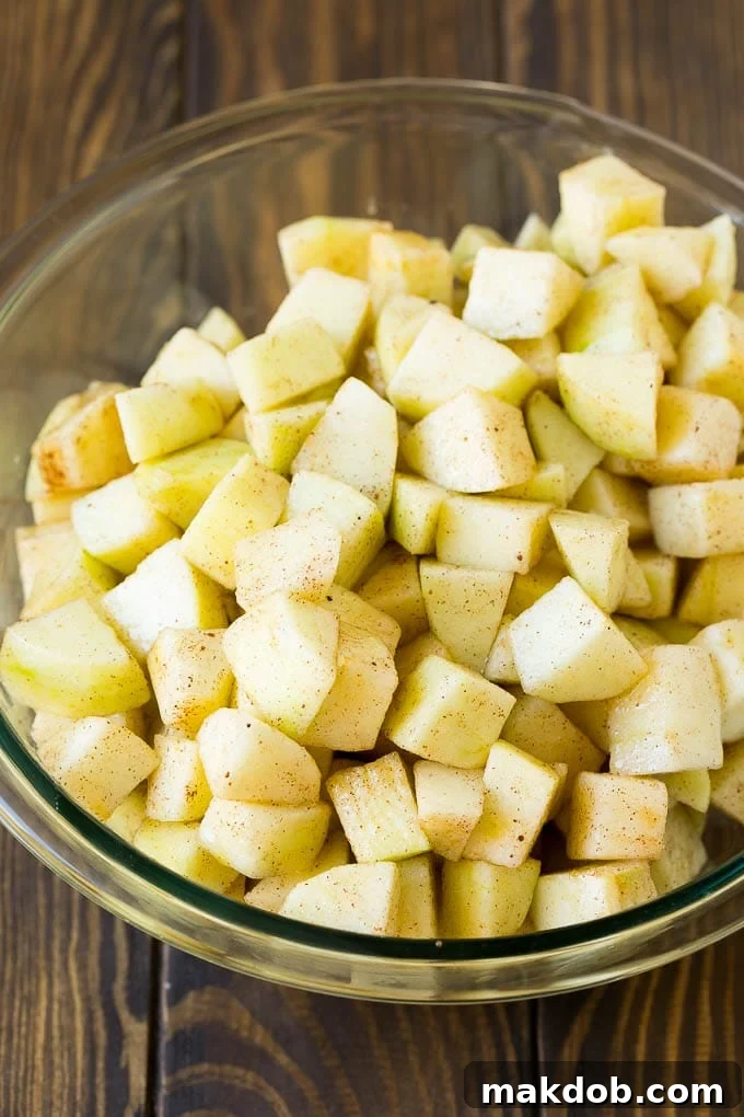 Apple Crisp Recipe | Apple Dessert #apples #dessert #baking #fall #dinneratthezoo Diced apples tossed with sugar and cinnamon in a bowl.