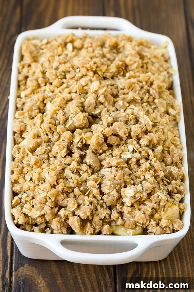 Apple Crisp Recipe | Apple Dessert #apples #dessert #baking #fall #dinneratthezoo Apples in a baking dish topped with brown sugar crumble.