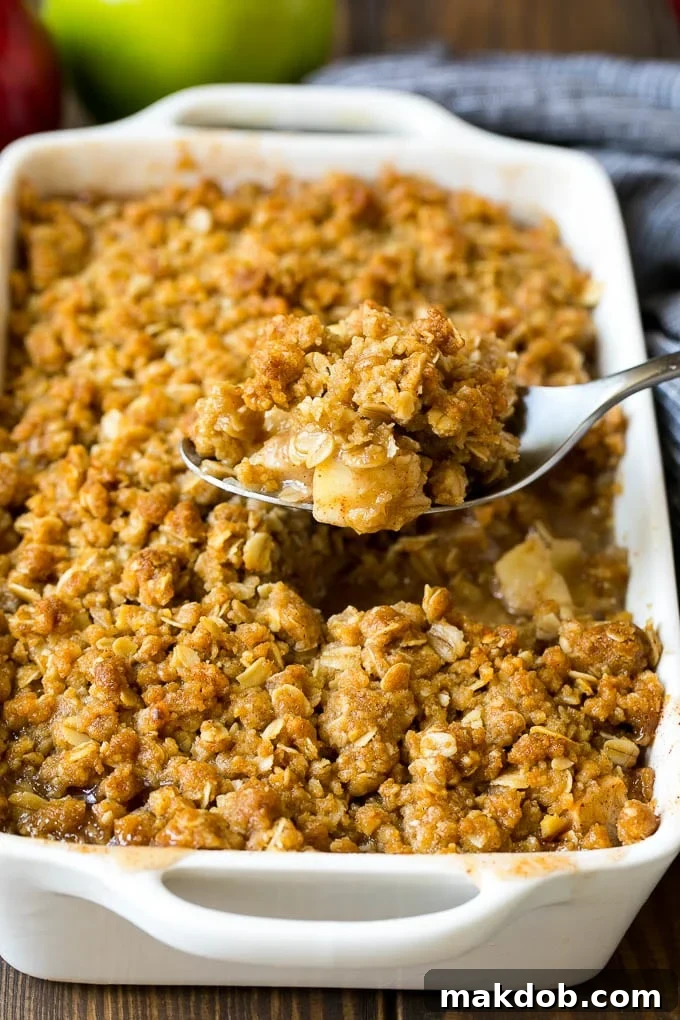 Apple Crisp Recipe | Apple Dessert #apples #dessert #baking #fall #dinneratthezoo A spoon serving up a portion of apple crisp.