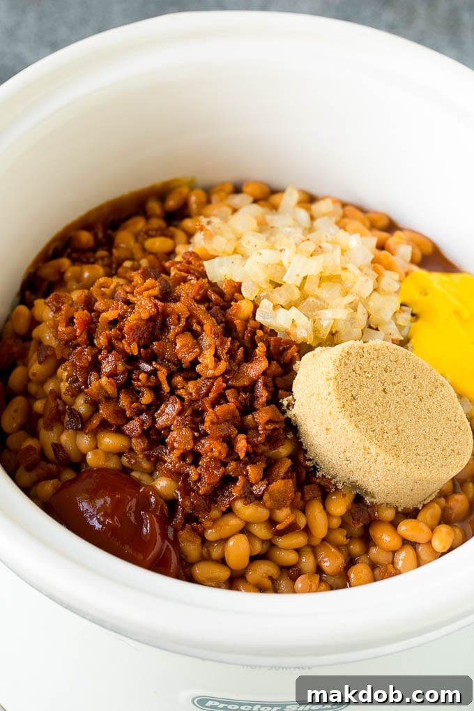 Crock Pot Baked Beans | Slow Cooker Baked Beans #beans #bacon #slowcooker #crockpot #dinneratthezoo Beans in a slow cooker with bacon, onions, brown sugar and seasonings.