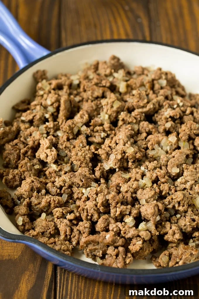 Ground beef with onions in a skillet.