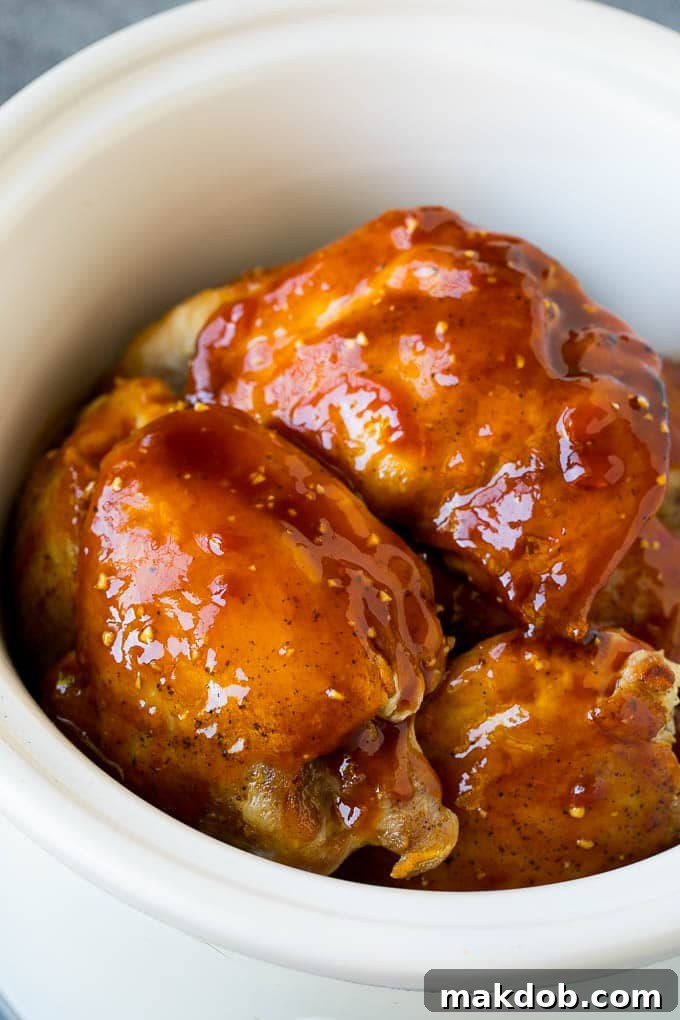 A vibrant close-up of tender chicken thighs generously coated in a glistening, thick honey garlic sauce.
