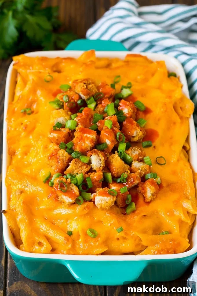 Buffalo chicken pasta topped with melted cheese, chicken pieces, and fresh celery and green onions.