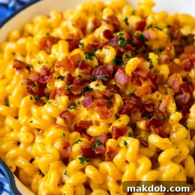 Bacon mac and cheese in a skillet, garnished with chopped parsley.