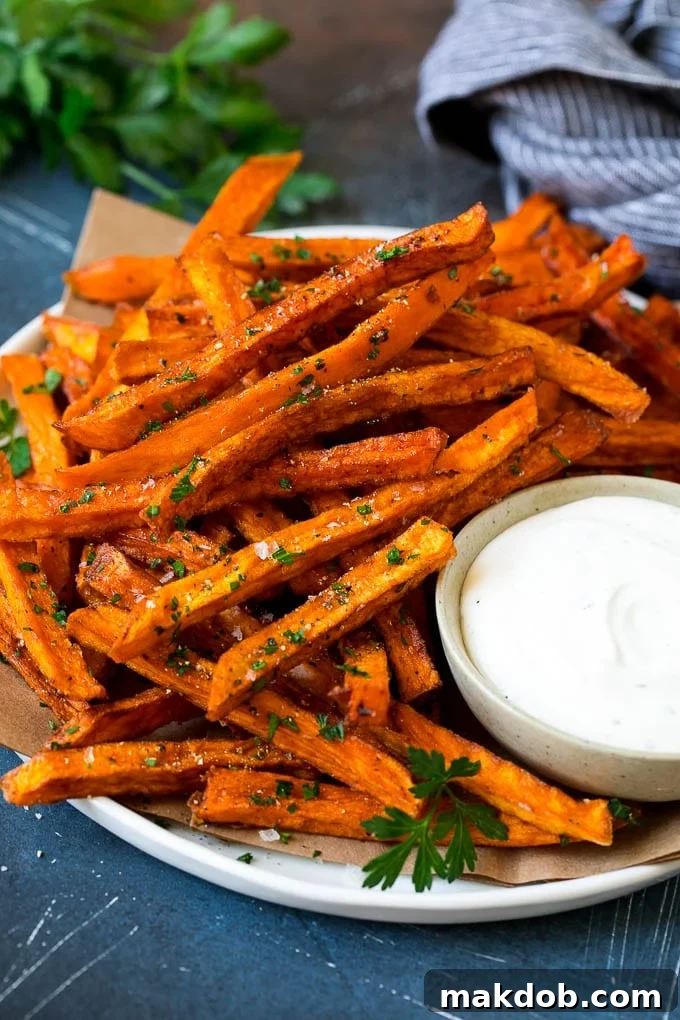 Sweet Potato Fries Recipe | Baked Sweet Potato Fries | Homemade Fries #fries #sweetpotato #sidedish #frenchfries #dinner #dinneratthezoo A plate of sweet potato fries with ranch dip on the side.
