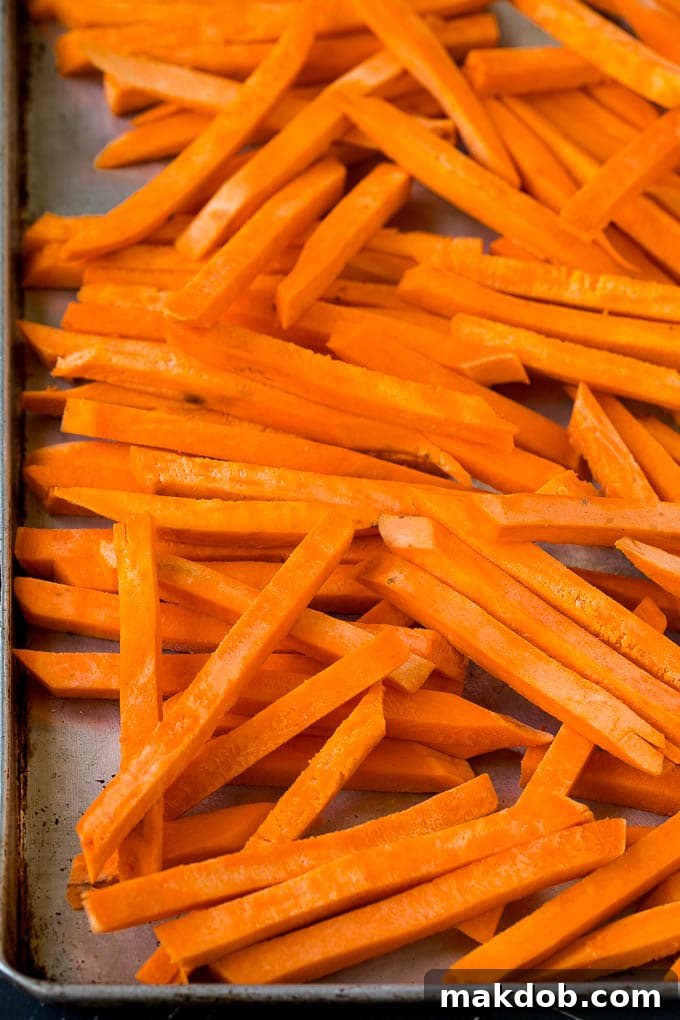 Sweet Potato Fries Recipe | Baked Sweet Potato Fries | Homemade Fries #fries #sweetpotato #sidedish #frenchfries #dinner #dinneratthezoo Cut sweet potatoes on a sheet pan.