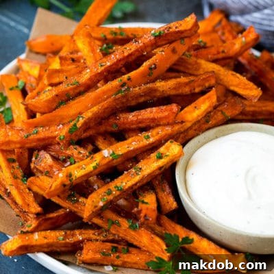 A plate of sweet potato fries with ranch dip on the side.