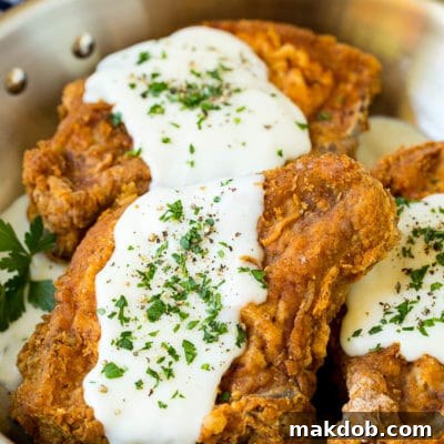 Fried pork chops topped with creamy gravy and parsley.