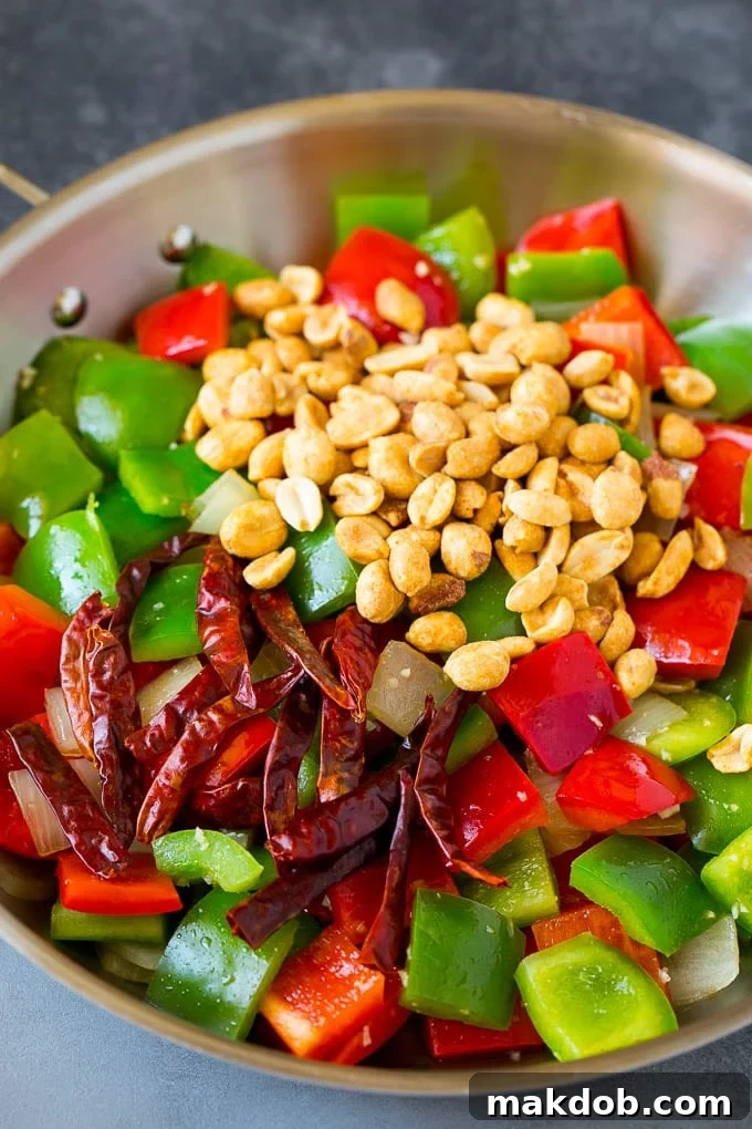 Kung Pao Chicken Recipe | Chicken Stir Fry #chicken #stirfry #chinesefood #peanuts #peppers #dinner #dinneratthezoo Bell peppers, peanuts and red chilies in a skillet.