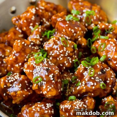 General Tso's chicken coated in a sweet and spicy sauce, then topped with sesame seeds.