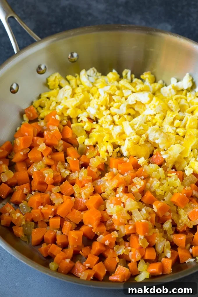 Scrambled eggs and mixed vegetables in a pan.