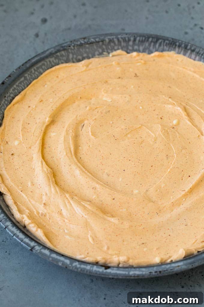 A mixture of sour cream, cream cheese and taco seasoning in a serving dish.