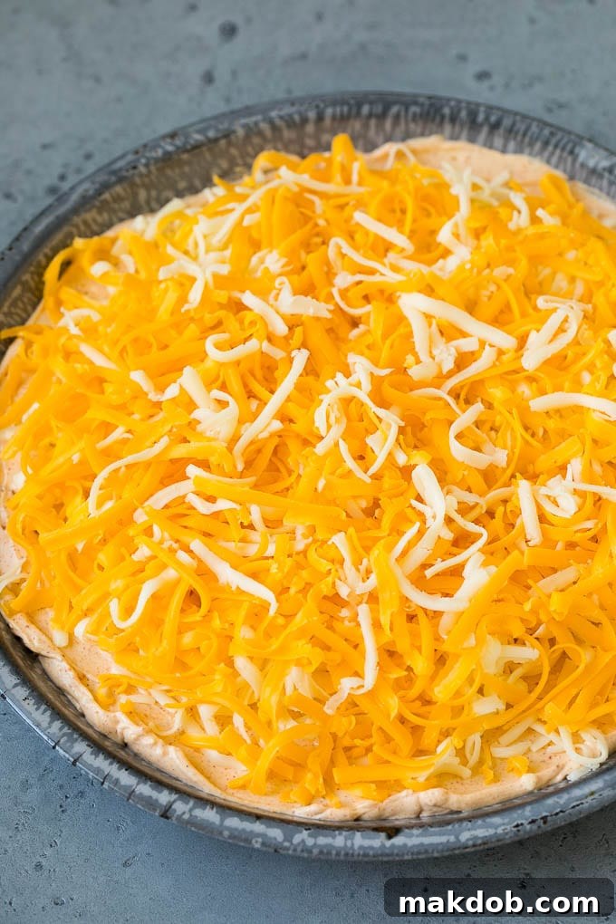 Shredded cheese sprinkled over taco flavored cream cheese and sour cream.