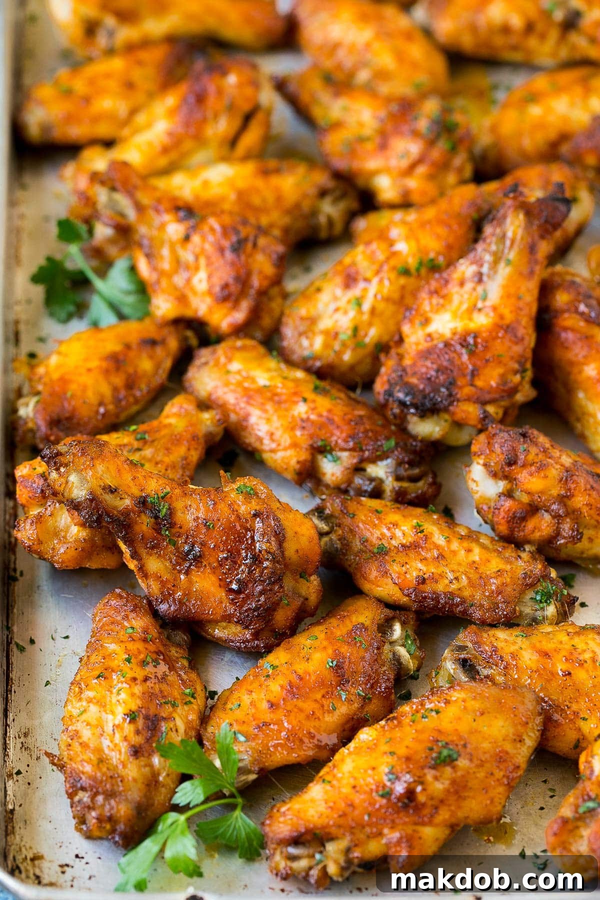 Crispy Oven Wings 5 A tray of cooked chicken garnished with parsley.