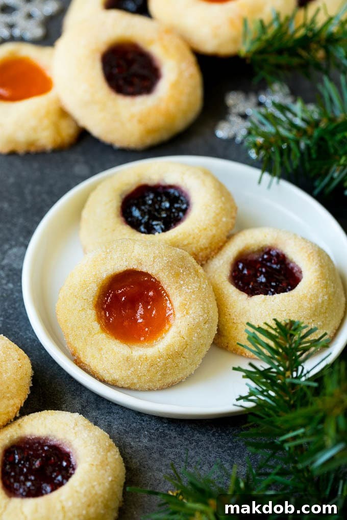 Classic Jam Thumbprint Cookies | Sugar Cookies with Jam Filling #cookies #baking #christmas #dessert #homemade A beautiful plate showcasing an assortment of jam-filled thumbprint cookies, ready to be enjoyed.