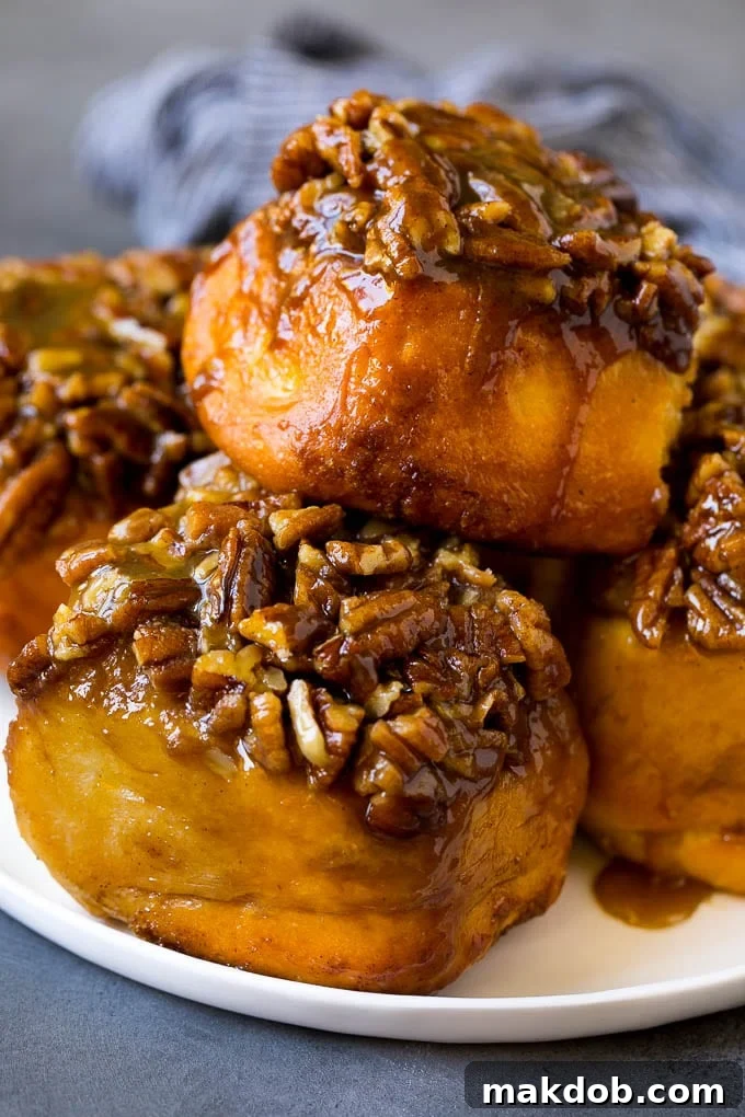 Sticky Buns Recipe | Sweet Rolls | Cinnamon Rolls #breakfast #brunch #cinnamon #pecans #dinneratthezoo #bread A plate of sticky buns topped with chopped nuts.