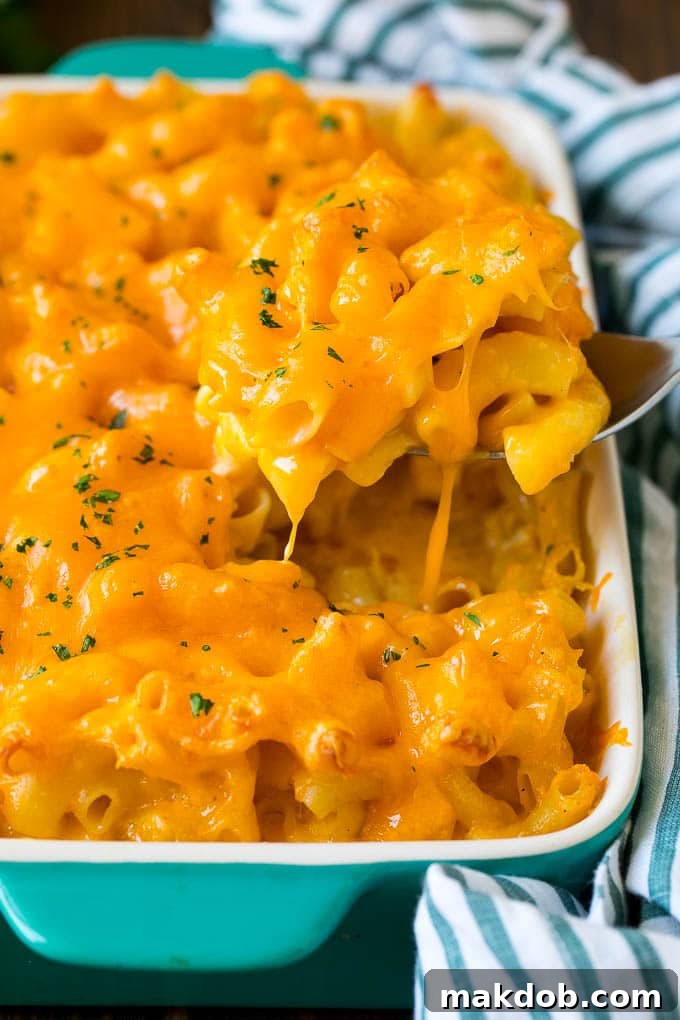 A spoon serving up a portion of Southern mac and cheese, revealing its creamy, baked interior.