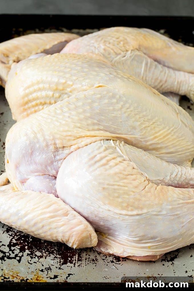 Spatchcock Turkey | Roasted Turkey | Thanksgiving Turkey #turkey #thanksgiving #dinner #fall #christmas #dinneratthezoo A flattened whole turkey on a sheet pan.