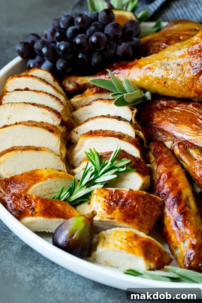 Spatchcock Turkey | Roasted Turkey | Thanksgiving Turkey #turkey #thanksgiving #dinner #fall #christmas #dinneratthezoo Sliced spatchcock turkey on a serving platter garnished with herbs.